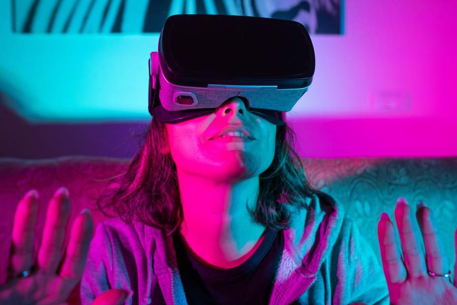 Frau mit VR-Brille reagiert auf etwas, das sie im Metaversum sieht